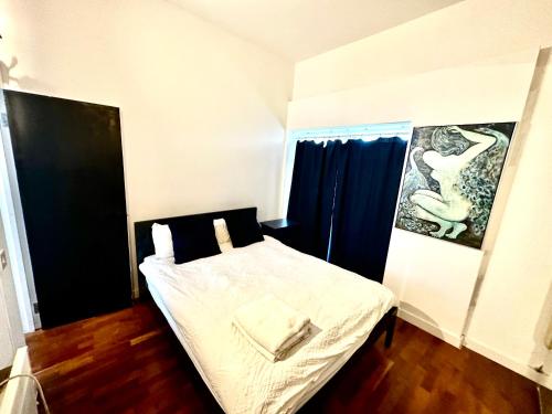 a bedroom with a bed and a picture of a swan at Shoreditch apartment with lovely garden in London