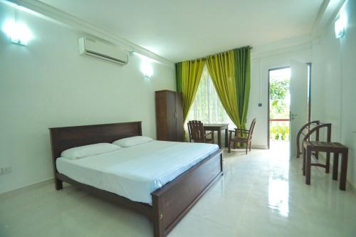 una camera con letto, tavolo e sedie di Habarana Spice Village Hotel & Restaurant a Moragaswewa