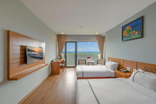 a hotel room with two beds and a television at Fansipan Da Nang Hotel in Danang