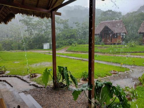 a view of a farm from a house in the rain at Kotsimba Lodge in Puerto Leguía