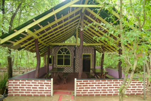 a small brick house with a wooden roof at Spice Village Hotel & Restaurant in Habarana
