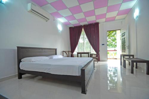 a bedroom with a bed with a pink and white ceiling at Spice Village Hotel & Restaurant in Habarana