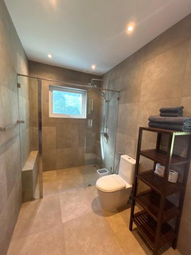 a bathroom with a toilet and a shower at Nanai Resort Salakphet in Ko Chang