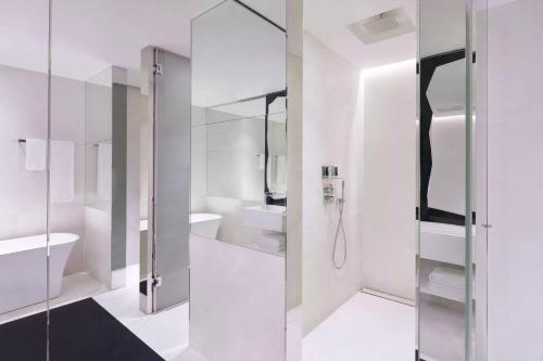 a white bathroom with a shower and a sink at JW Marriott Hotel Singapore South Beach in Singapore