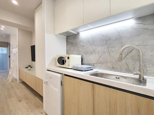a kitchen with a sink and a microwave at STAY ARI Shinjuku Gyoen 6Min walk in Tokyo