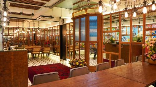 a restaurant with a large wooden table and chairs at The Payang Hotel in Kuala Terengganu