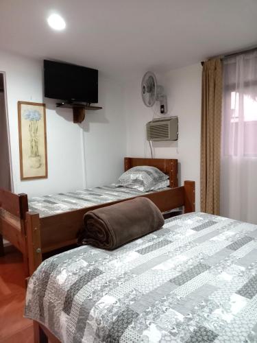 a bedroom with two beds and a flat screen tv at Chavenogue Hotel in San Juan