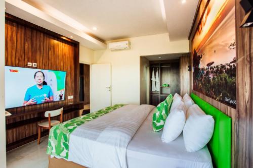 a hotel room with a bed and a flat screen tv at Sylvia Hotel & Resort Komodo in Labuan Bajo