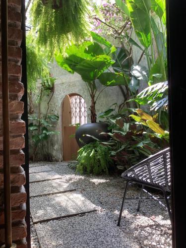 a patio with a chair and a door in a garden at The Opposite Place in Melaka