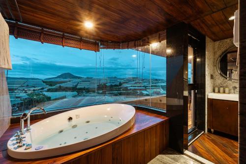 a bath tub in a bathroom with a large window at Biệt Thự Nam Hồ Đà Lạt - Villa Luxury Nam Hồ in Khu Chi Lăng
