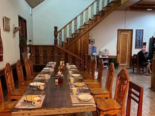 a long wooden table in a room with chairs at Pukyo Bed and breakfast Belgian lao in Ban Nangoy