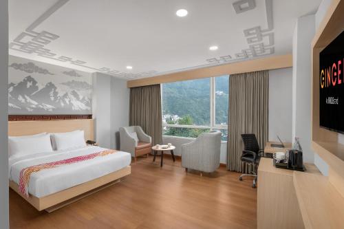 a bedroom with a bed and a desk and a television at Ginger Gangtok in Gangtok