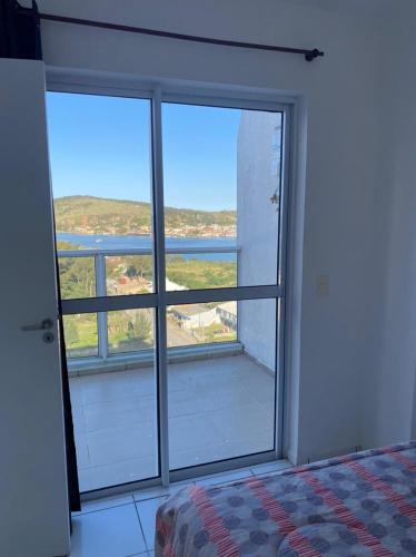 ラグーナにあるCobertura Mar grossoのベッドルーム1室(景色を望む大きな窓付)