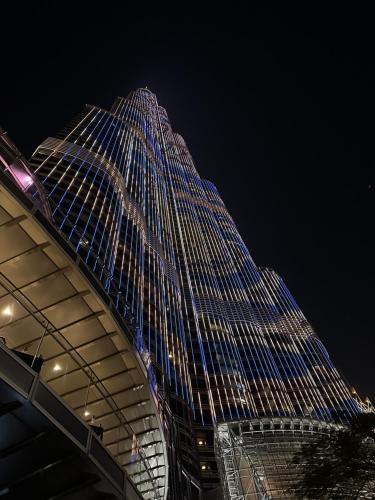 un edificio alto con luces azules por la noche en Burj Khalifa en Dubái