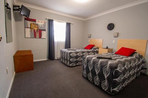 um quarto de hotel com duas camas e uma janela em Gundagai Motel em Gundagai