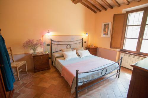 una camera da letto con un letto, una sedia e finestre di Il Vecchio Mulino Toscana a Radicondoli