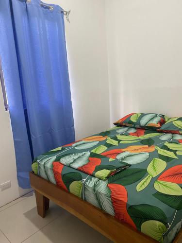 a bed with a colorful comforter in a room at Casa Zion in San Juanillo