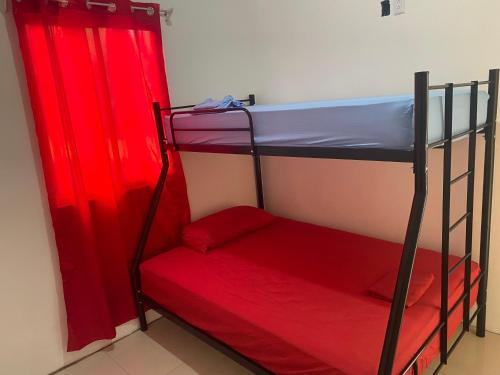 two bunk beds in a room with red curtains at Casa Zion in San Juanillo