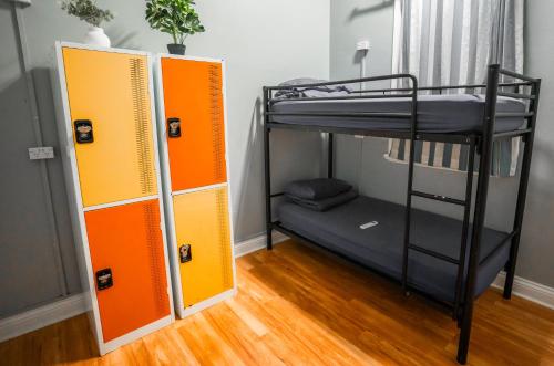 a bunk bed with orange and black dividers in a room at Mad Monkey Central in Cairns