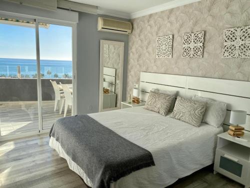 1 dormitorio con 1 cama grande y balcón en APARTAMENTO CON VISTAS AL MAR, en Torremolinos