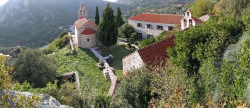 a church on top of a hill next to a building at Guest House Oleander in Petrovac na Moru
