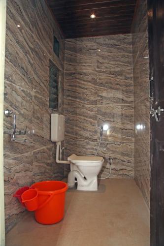 a bathroom with a toilet and two buckets at Hotel Madhusudan Executive in Kolhapur