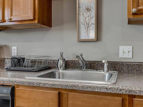 a kitchen counter with a stainless steel sink at Deluxe Studio in Historic Downtown Building! in Bartlesville