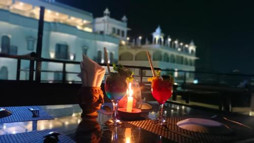 una mesa con dos velas y dos vasos en un balcón en Omkar Palace, en Udaipur