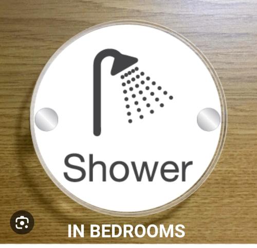 a white button with a shower in bedrooms on it at Hutton Lodge in Middlesbrough