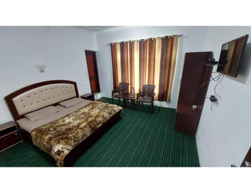 a bedroom with a bed and a table and chairs at HOTEL EVERGREEN SUNSHINE, Srinagar in Srinagar