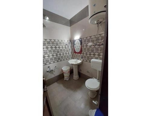 a bathroom with a toilet and a sink at HOTEL EVERGREEN SUNSHINE, Srinagar in Srinagar