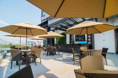an outdoor patio with tables and chairs with umbrellas at Best Western Plus Metro Clark in Angeles