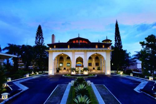 TripleTree Hotel And Resort Bukittinggi في بوكيتينجى: مبنى كبير مع فناء في الأمام