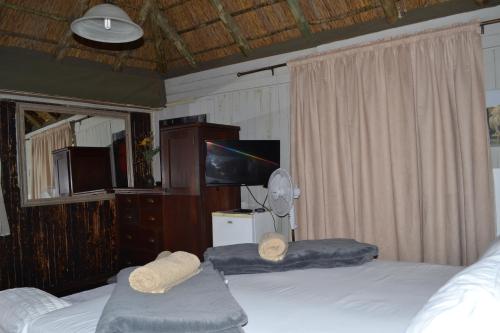 a bedroom with two beds and a flat screen tv at Thorn Tree Bloemfontein in Bloemfontein