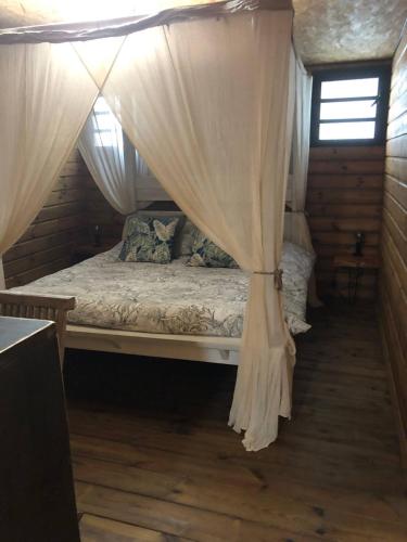 Bett in einem Zimmer mit Baldachin in der Unterkunft Kaz Laverdure in Saint-Denis