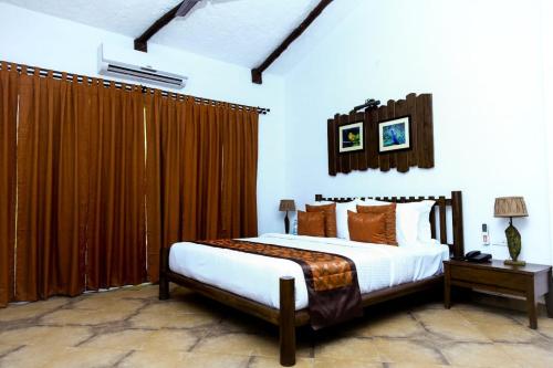 een slaapkamer met een groot bed en bruine gordijnen bij Anaya Resort in Kota