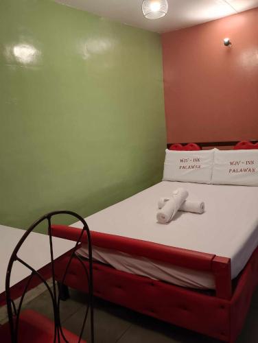 a bed in a room with a red and green wall at WJV INN PALAWAN in Puerto Princesa City