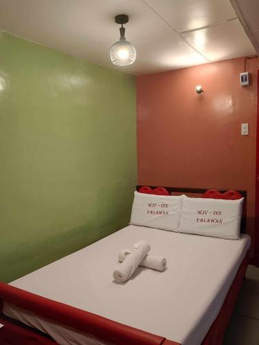 a bed in a room with a green wall at WJV INN PALAWAN in Puerto Princesa City