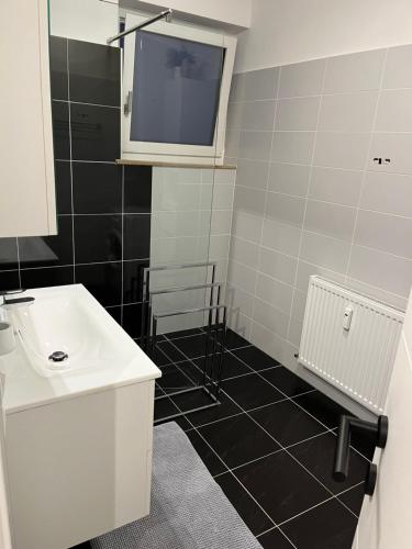 a bathroom with a sink and a tv on the wall at AAA FeWo Bad Gastein/Böckstein in Bad Gastein