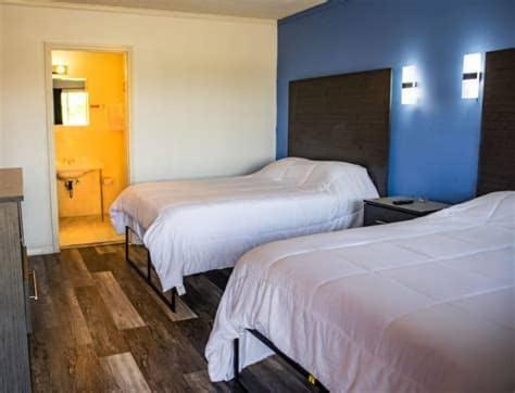 ein Hotelzimmer mit 2 Betten und einer blauen Wand in der Unterkunft American Inn in Dermott