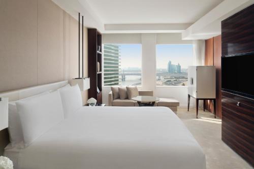 a bedroom with a white bed and a living room at InterContinental Dubai Festival City, an IHG Hotel in Dubai