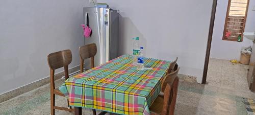 a kitchen with a table and a refrigerator at Major Madi Residency in Puducherry