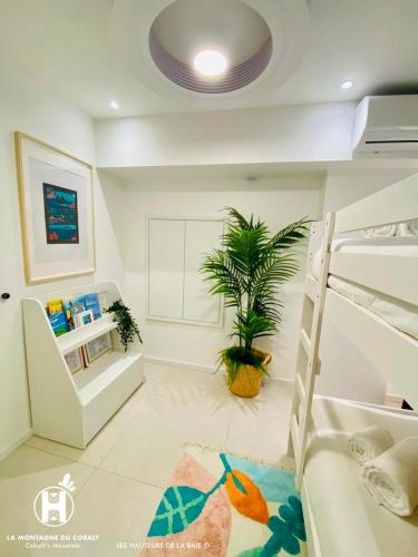 a bedroom with a bunk bed and a palm tree at Les Hauteurs de la Baie in Noumea