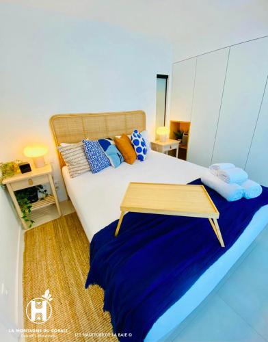 a bedroom with a bed with a table on it at Les Hauteurs de la Baie in Noumea