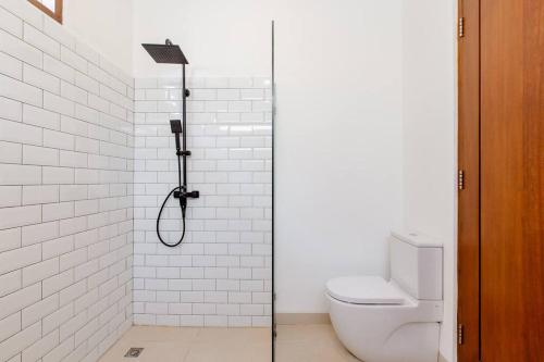 a bathroom with a shower with a toilet and a shower head at New Cozy 2-b Villa in Canggu in Munggu