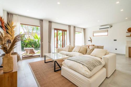 a living room with a white couch and a table at New Cozy 2-b Villa in Canggu in Munggu