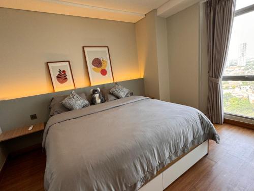 ein Schlafzimmer mit einem großen Bett und einem Fenster in der Unterkunft Pejaten Park Residence in Jakarta