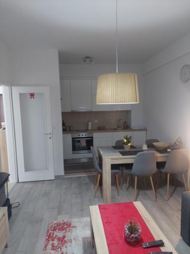 a kitchen and dining room with a table and chairs at Apartman Tea in Kupres