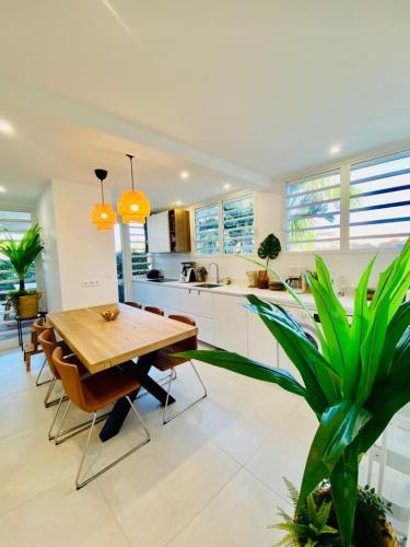 a large kitchen with a wooden table and chairs at Les Hauteurs de la Baie in Noumea