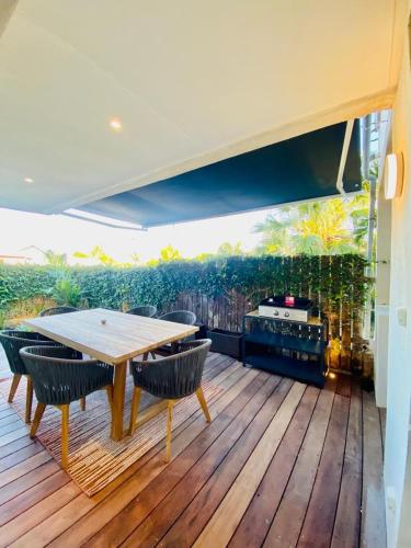 a patio with a table and chairs on a deck at Les Hauteurs de la Baie in Noumea